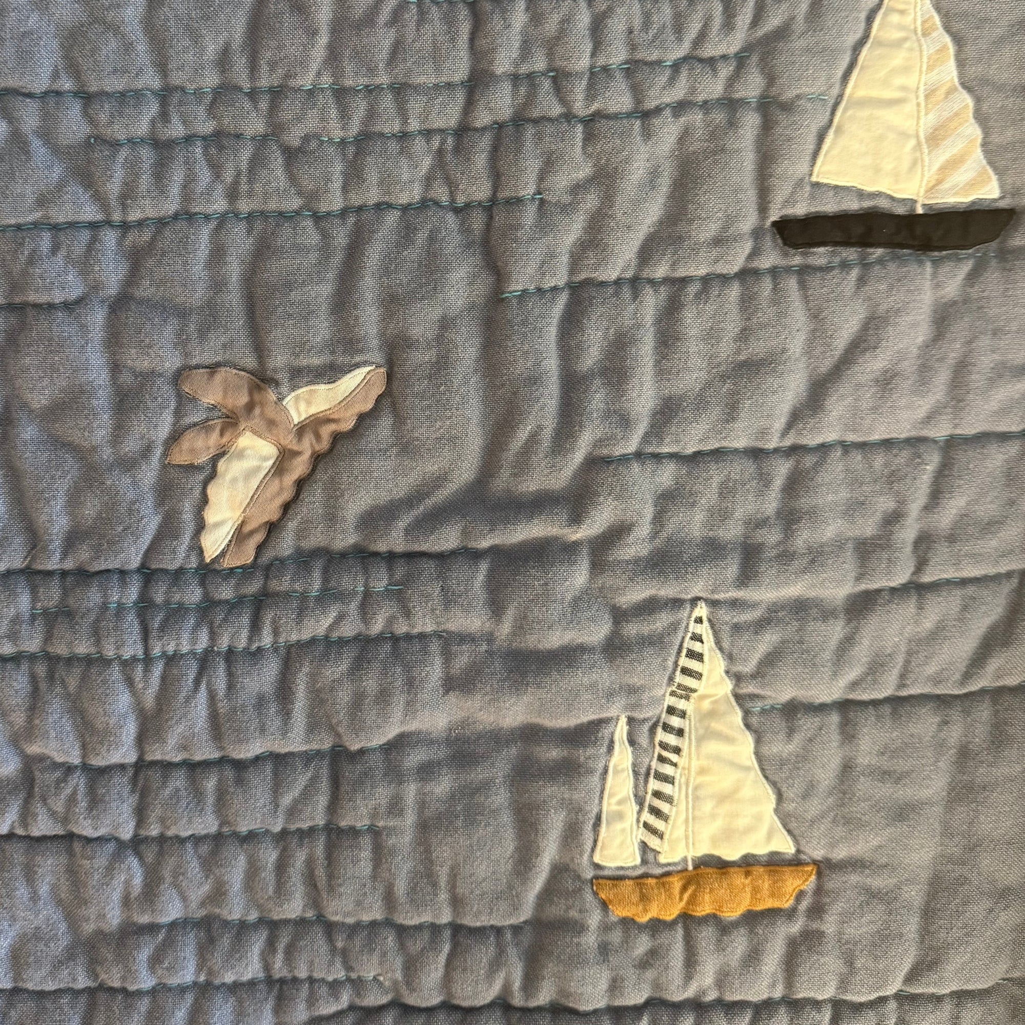 Applqued whale jumping out of the water on Haptic Lab's sailboat quilt