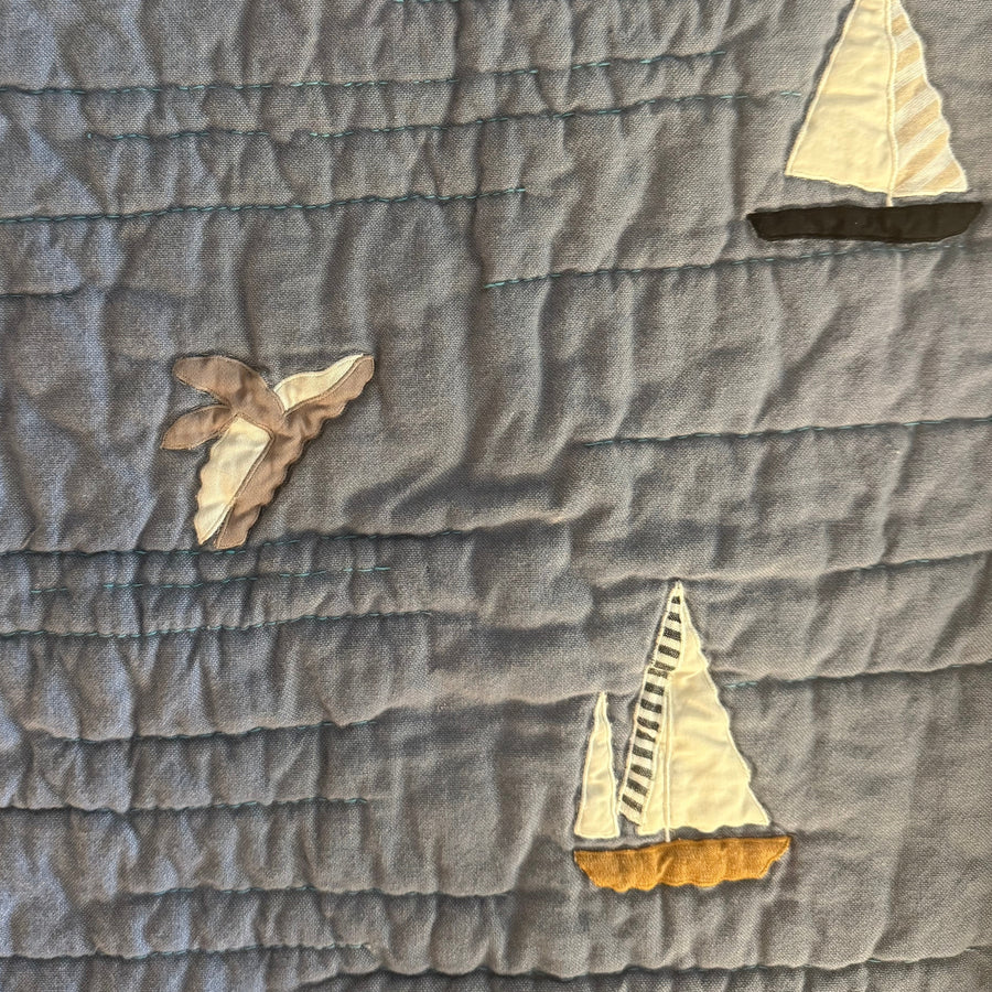 Applqued whale jumping out of the water on Haptic Lab's sailboat quilt