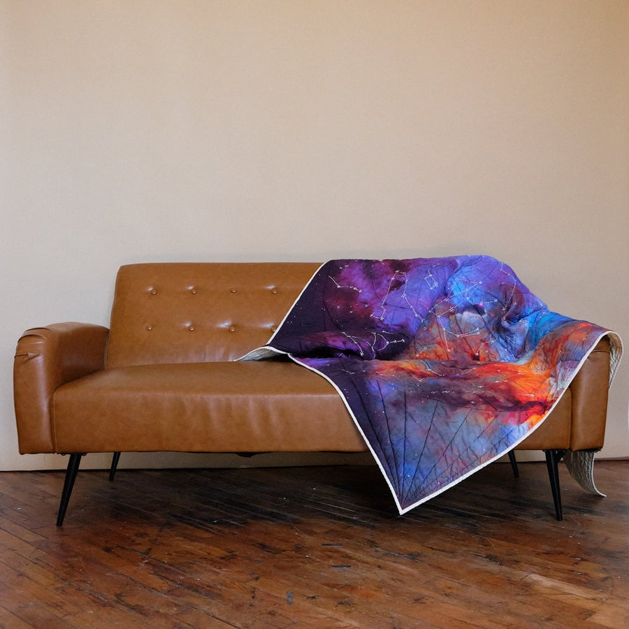 Galileo Quilt by Haptic Lab draped on couch 