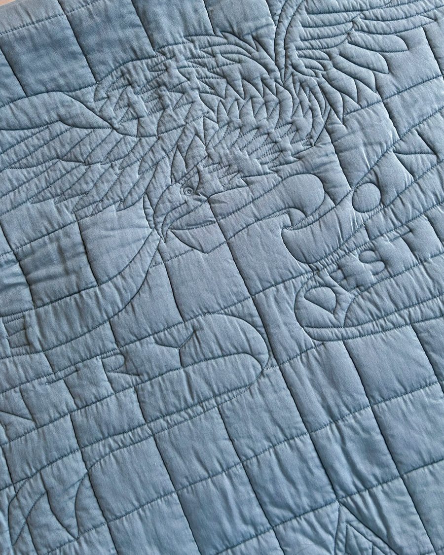 Close-up of quilted blue fabric with an American eagle