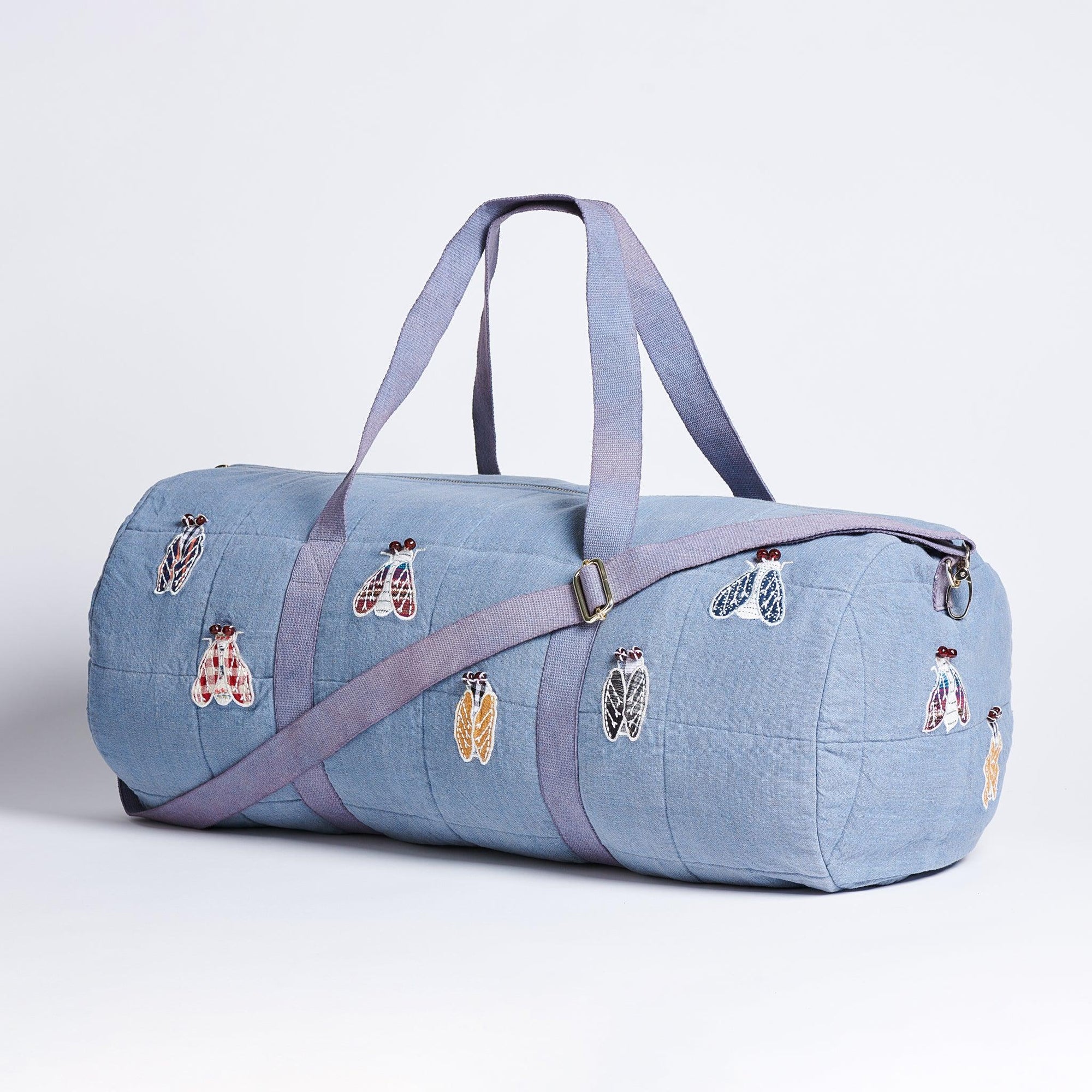 Light Blue Duffle with appliquéd cicada's on a white background.  