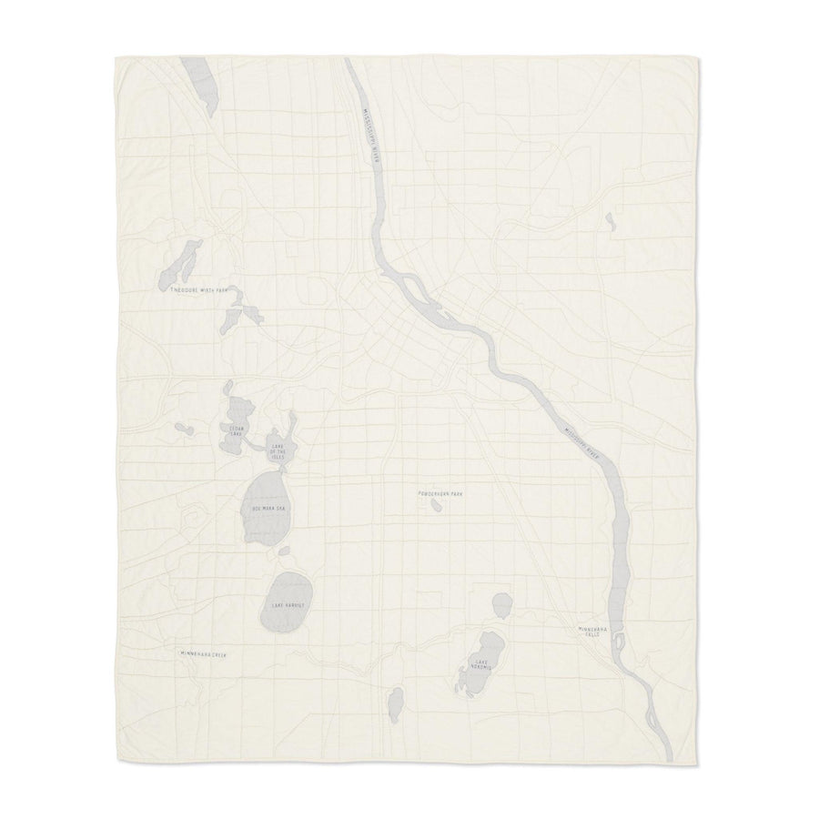 Heirloom quilt, a hand-stitched map of Minneapolis with ivory land and gray water.
